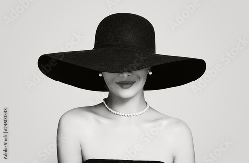 Black and white portrait of vintage woman in classic hat and pearls jewelry, retro styling girl photo