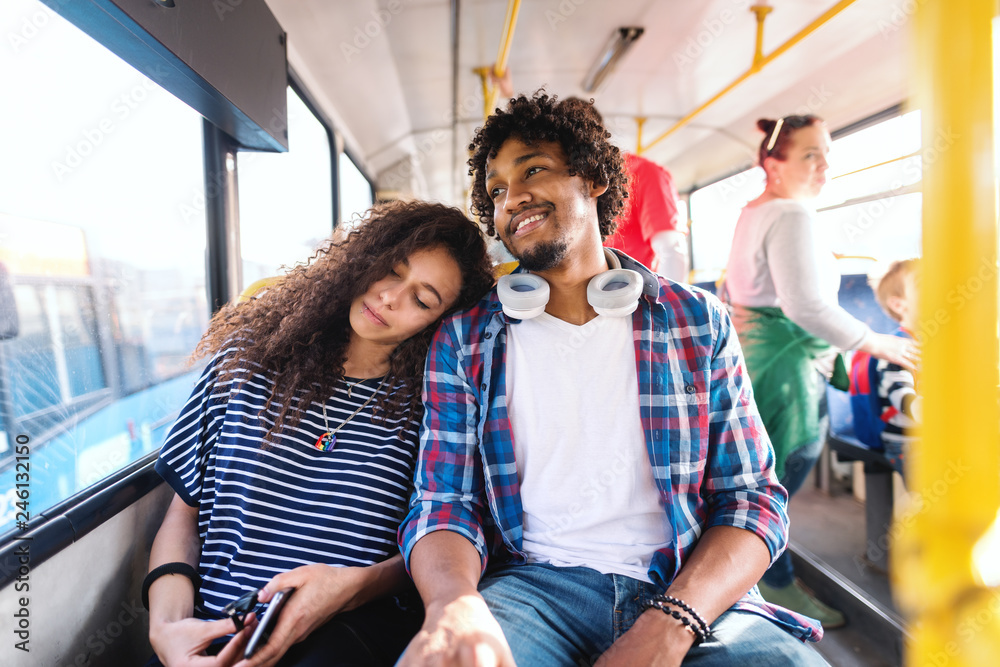 Couple sitting and riding in the city bus. Girl sleeping and leaning