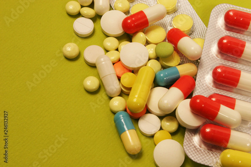 Pharmaceutical medicament, cure in container for health and heart on green background.