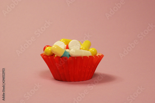 Pharmaceutical medicament, cure in container for health and heart on pink background.