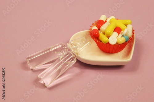 Pharmaceutical medicament, cure in container for health and heart on pink background.