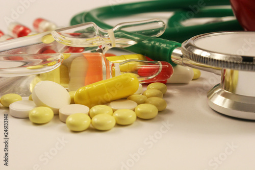 Pharmaceutical medicament, cure in container for health, stethoscope on white background.
