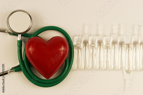 Pharmaceutical medicament, cure in container for health, stethoscope and heart on white background.