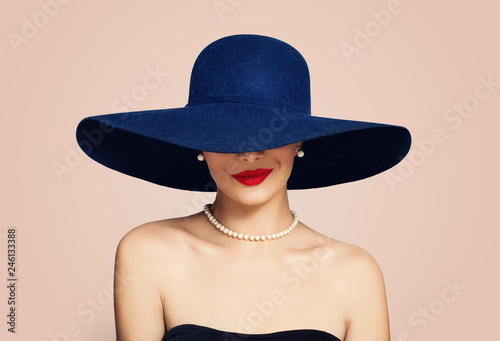 Beautiful smiling woman in elegant hat on pink background. Stylish girl with red lips makeup, fashion portrait photo