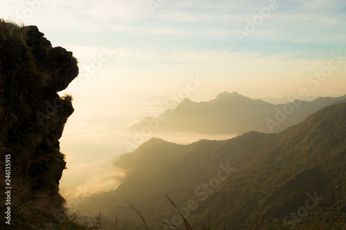 lion head shaped huge cliff with fog and mountains in the morning © amstockphoto