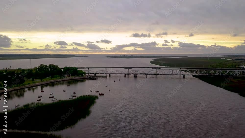 Aerial view of a river at sunset with a bridge Aerial view of a river at sunset with a bridge