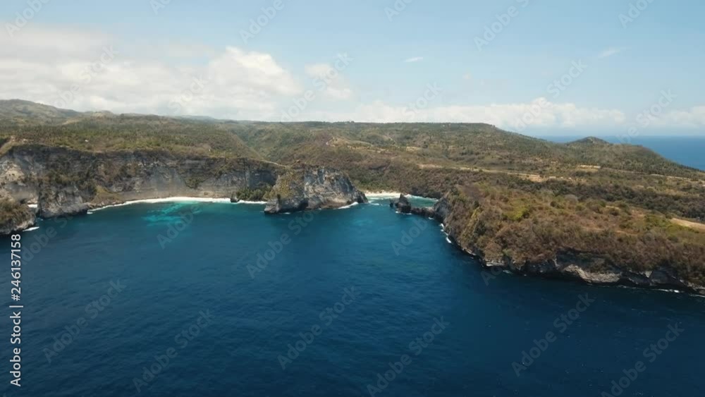 Aerial view of beautiful white sand. Clear blue ocean waves rolling to the beach. Nusa Penida, Bali, Indonesia. Travel concept. Aerial footage.