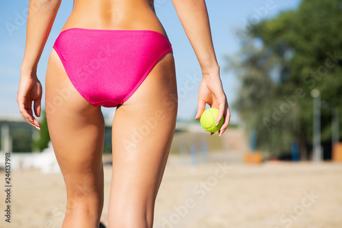 Closeup shot of fitness woman holding tennis ball. Back view. Copy space © vpavlyuk