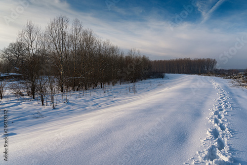 Path in the snow showing footsteps in winter time in sunset, low temperature, in the forest © Petar