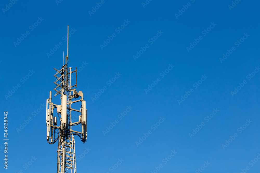 Telecom tower lit by sun on a bright blue sky Telecom tower lit by sun on a bright blue sky