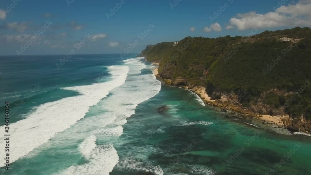 Aerial view of rocky coast, tropical beach with large wave. Large waves of turquoise water crushing on a beach Melasti, Bali,Indonesia. Travel concept. Aerial footage Aerial view of rocky coast, tropical beach with large wave. Large waves of turquoise water crushing on a beach Melasti, Bali,Indonesia. Travel concept. Aerial footage