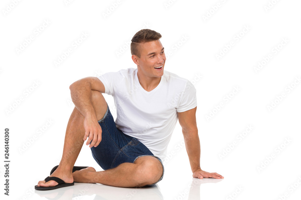 Cheerful Casual Man In White Shirt Sitting On Floor And Talking Cheerful Casual Man In White Shirt Sitting On Floor And Talking
