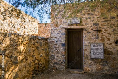 Fototapeta Naklejka Na Ścianę i Meble -  Entrance to the historic chapel at the cemetery on the leper island. Historic buildings in the Spinalonga fortress, Crete.