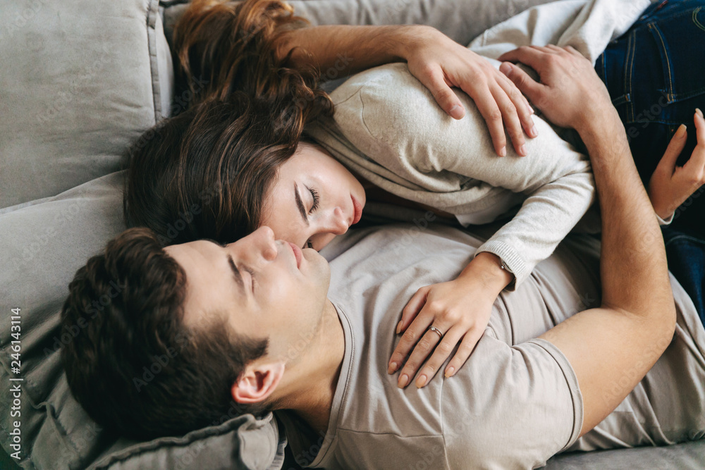 Happy young couple relaxing on a couch at home Happy young couple relaxing on a couch at home