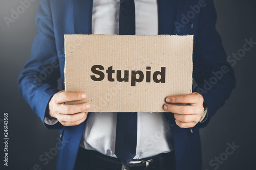 stupid text on paper on man hand photo