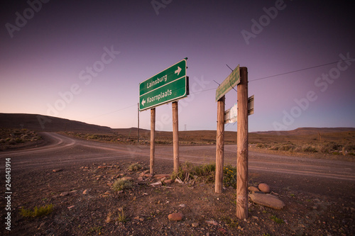 Wide angle view of roadsigns on a dirtroad, in the karoo region of south africa, showing the direction to the towns of Sutherland and Laingsburg photo