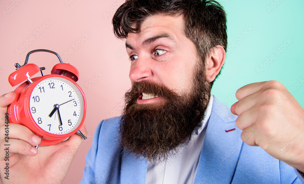 Time to work. Man bearded aggressive businessman hold clock. Stress concept. Hipster stressful working schedule. Businessman has lack of time. Time management skills. How much time till deadline - obrazy, fototapety, plakaty 