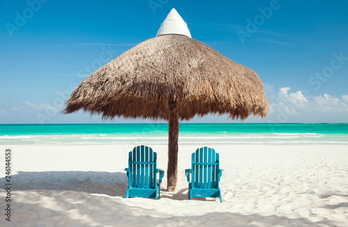 Fototapeta Naklejka Na Ścianę i Meble -  romantic getaway concept - tropical beach with two sun chairs under palapa