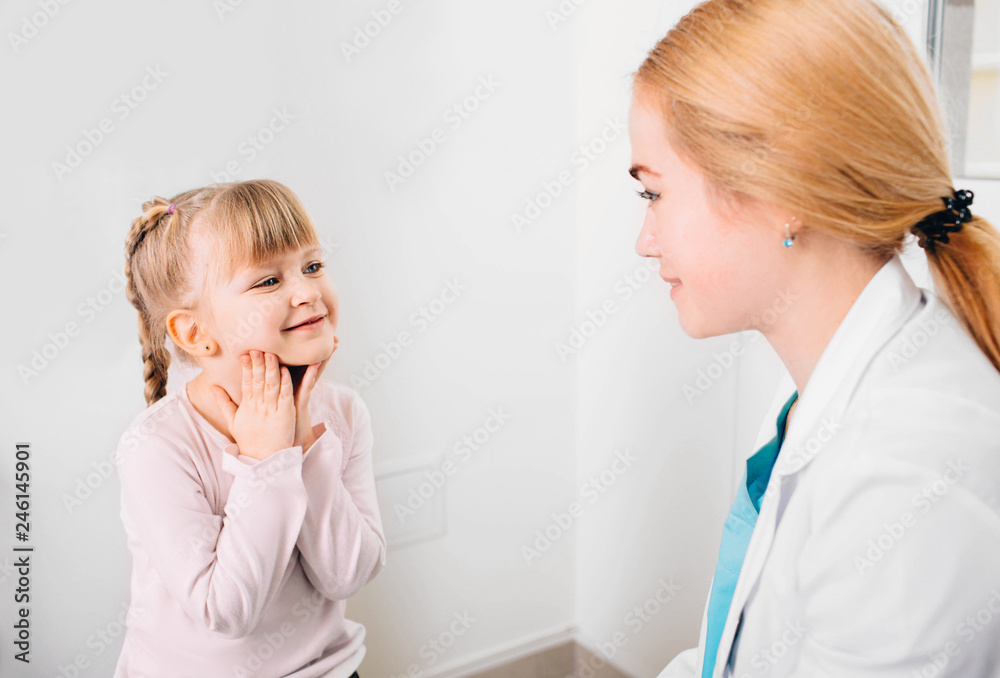 Caring doctor talks with her little patient at clinic