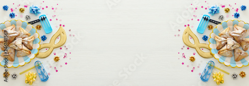 Purim celebration concept (jewish carnival holiday) over white wooden background. Top view, Flat lay.
