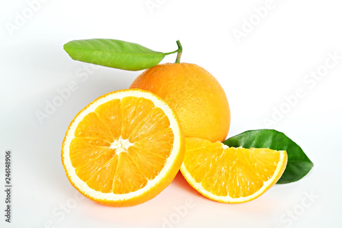 Close up image of juicy organic whole and halved oranges with green leaves & visible core texture, isolated yellow background, copy space. Macro shot of bright citrus fruit slices. Top view, flat lay.