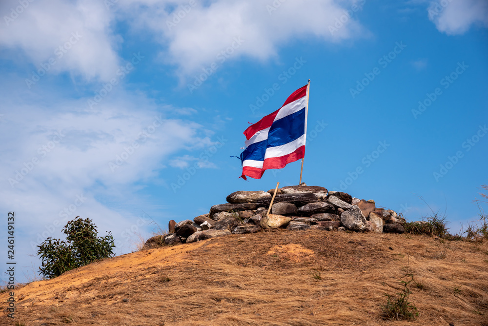 Image of waving Thai flag of Thailand with blue sky and mountain