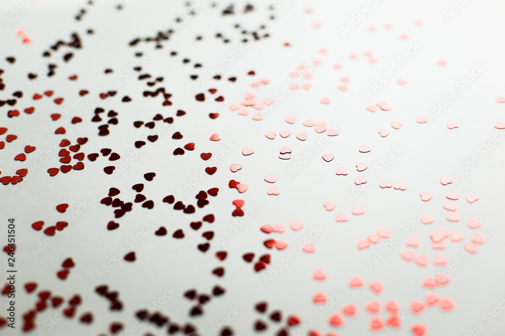  Beautiful background for a wedding or Valentine's Day. Small red heart-shaped blisters scattered on a white background macro shot, soft focus