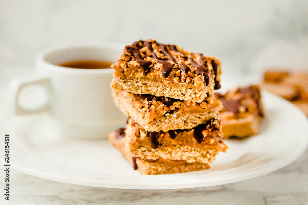 Paleo chocolate energy bars with rolled oats, nuts, dates caramel, chia seeds and coconut flakes. Horizontal.