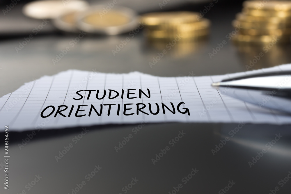 Studienorientierung auf einem Zettel mit Stift vor Geldmünzen Studienorientierung auf einem Zettel mit Stift vor Geldmünzen