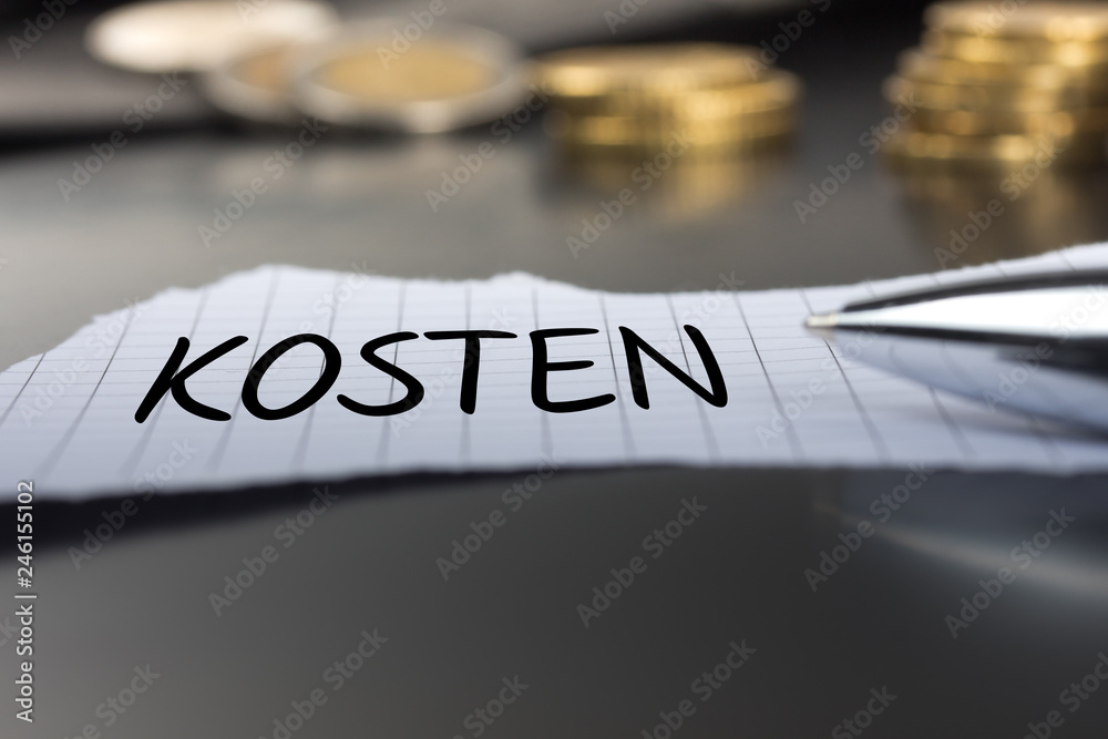 Kosten auf einem Zettel mit Stift vor Geldmünzen Kosten auf einem Zettel mit Stift vor Geldmünzen