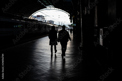 Silhouette of passengers in a train station.