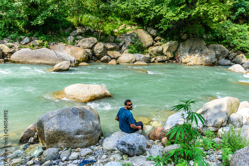 Man enjoying near the smooth flowing river with crystal clear water