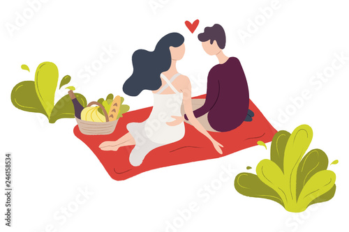A couple of young people sitting on a blanket in a park.
