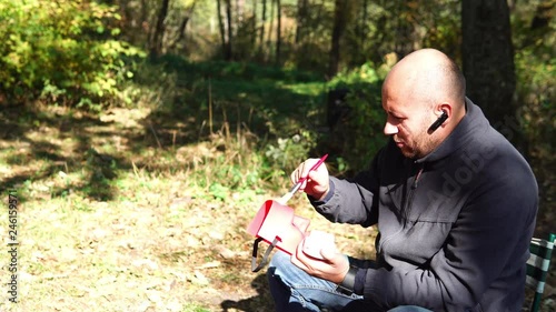 a man paints a mask outdoors