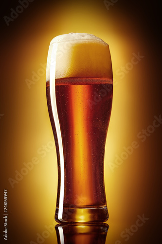 Classic dunkel beer in a glass studio shot on a gold gradient background.