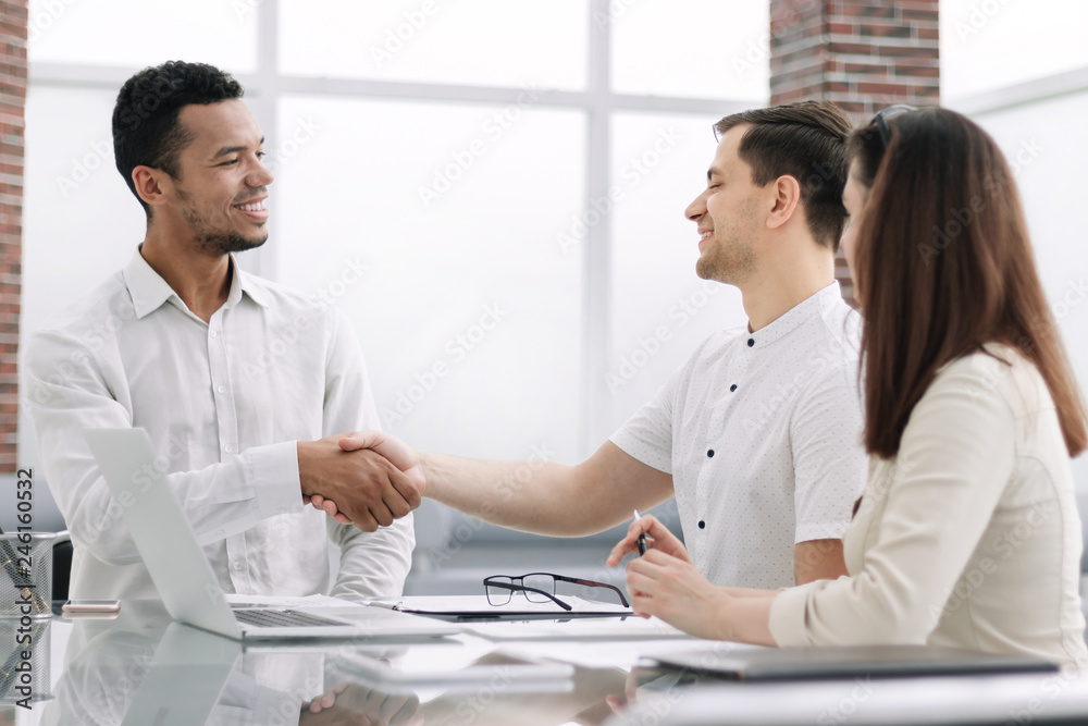 handshake business partners sitting at the office Desk handshake business partners sitting at the office Desk