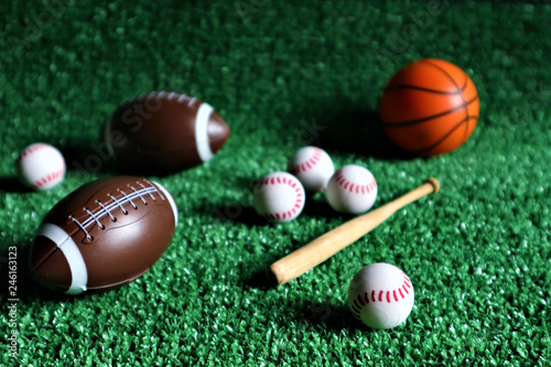 collection of several sport game balls such as football  soccer  and tennis  flying on a green background.