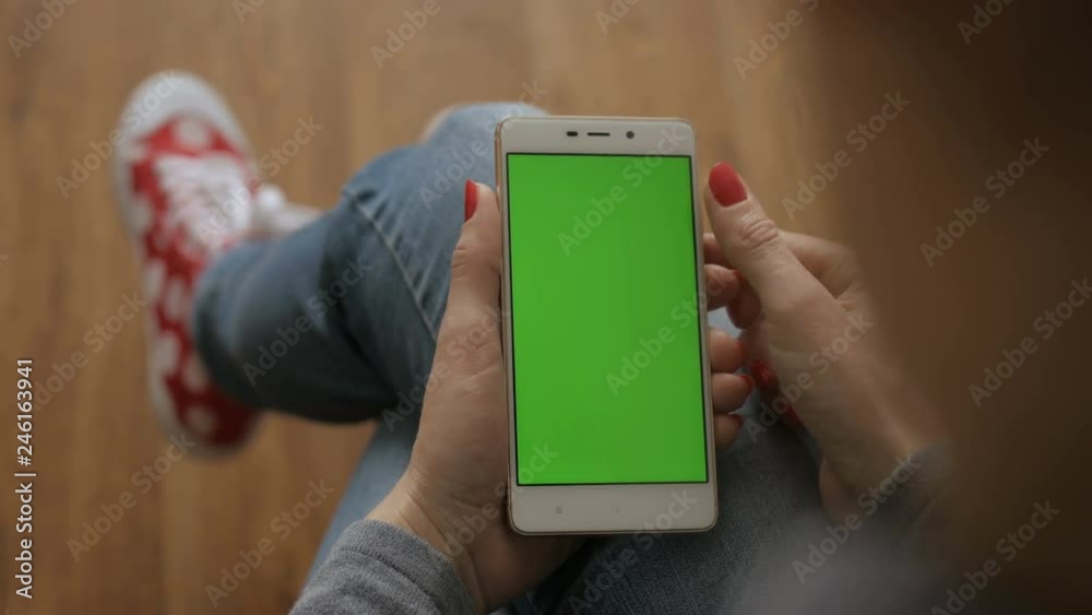Girl using cell phone.  Woman holding a smartphone in the hands of a green screen green screen, hand of man holding mobile smart phone with chroma key green screen on white background. Technology conc