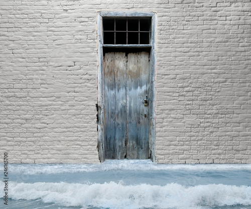 Klimawandel, hypothetische Wasserflut in einem Wohngebäude aufgrund der globalen Erwärmung. Die Flut kommt. Wasser kommt aus einer alten Wohnungshaustür. © FrauPixel
