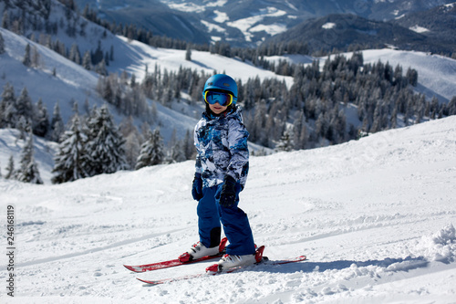 Cute preschool child, skiing in Austrian winter resort on a clear day