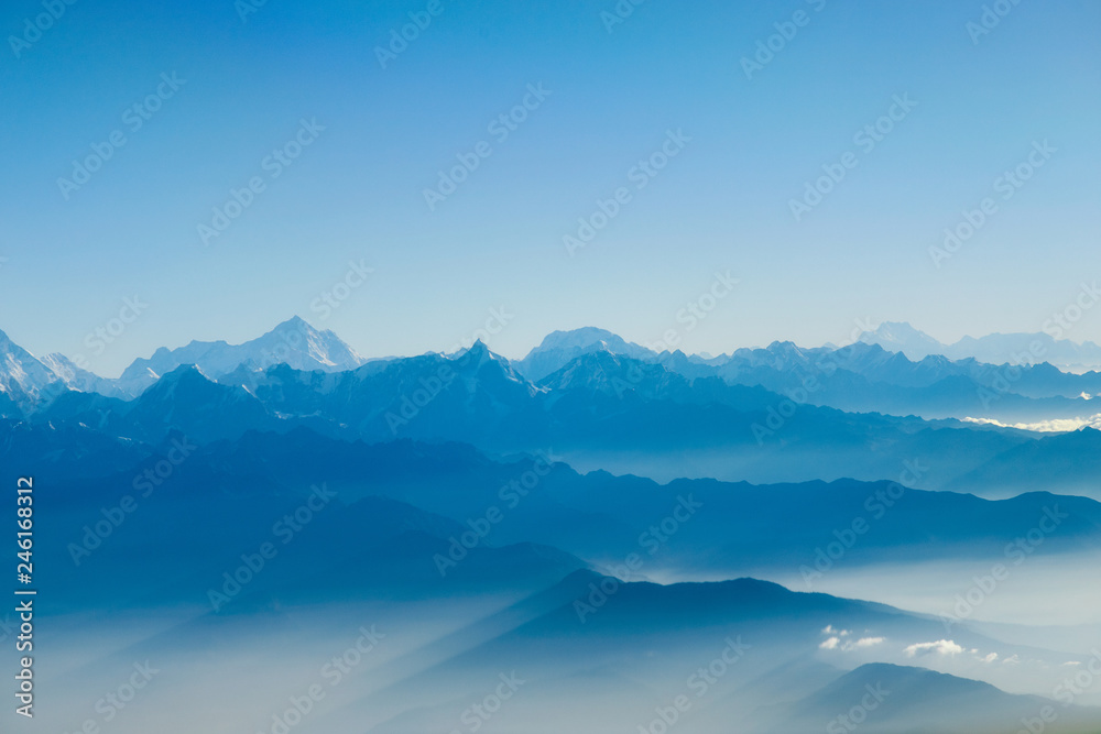 Ray of light through layer of mountains in the morning.