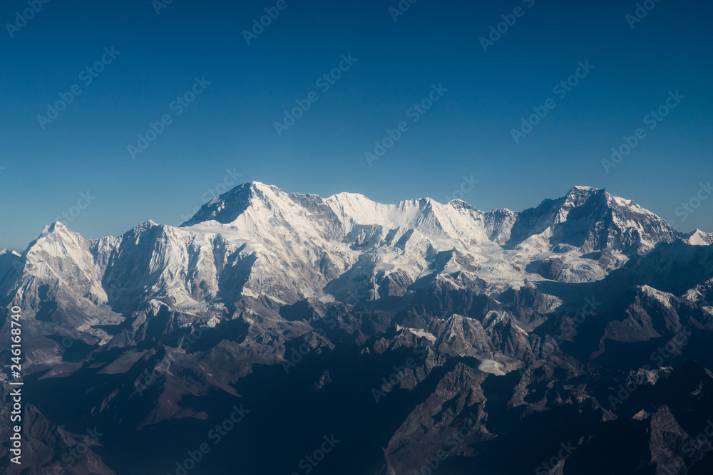 Scenic view of Himalayan mountain range with clear blue sky and snow capped peaks.