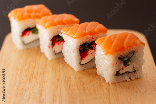 sushi roll with salmon on wooden board