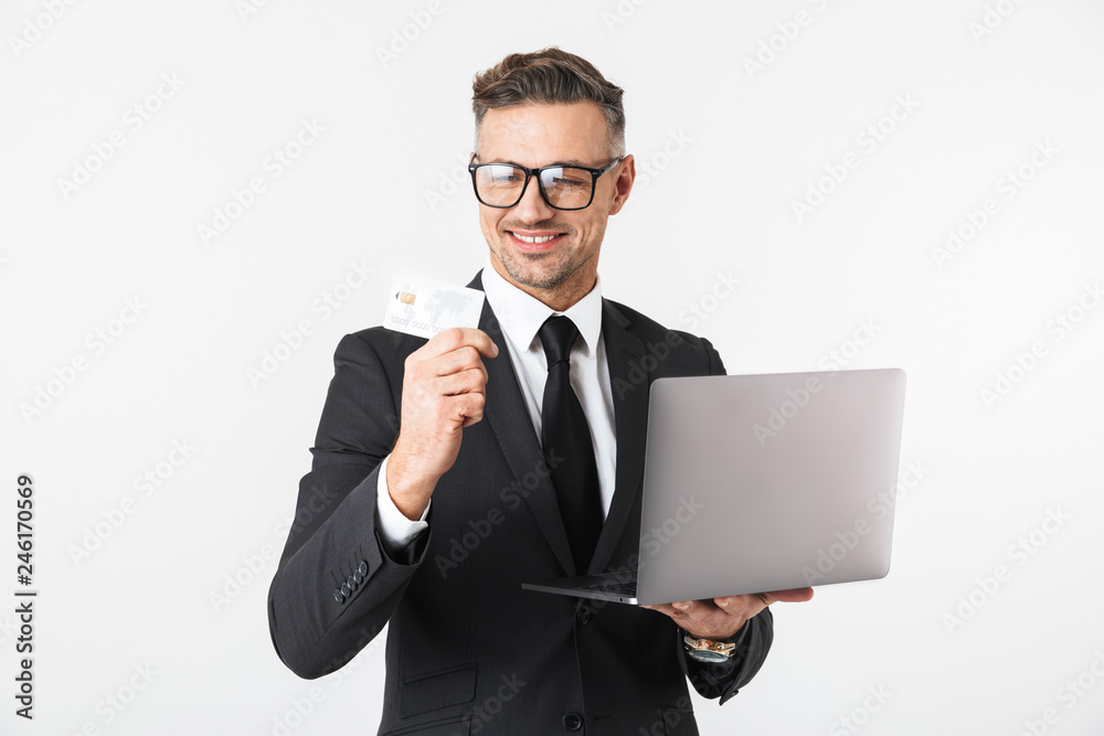 Handsome business man isolated over white wall background using laptop computer.