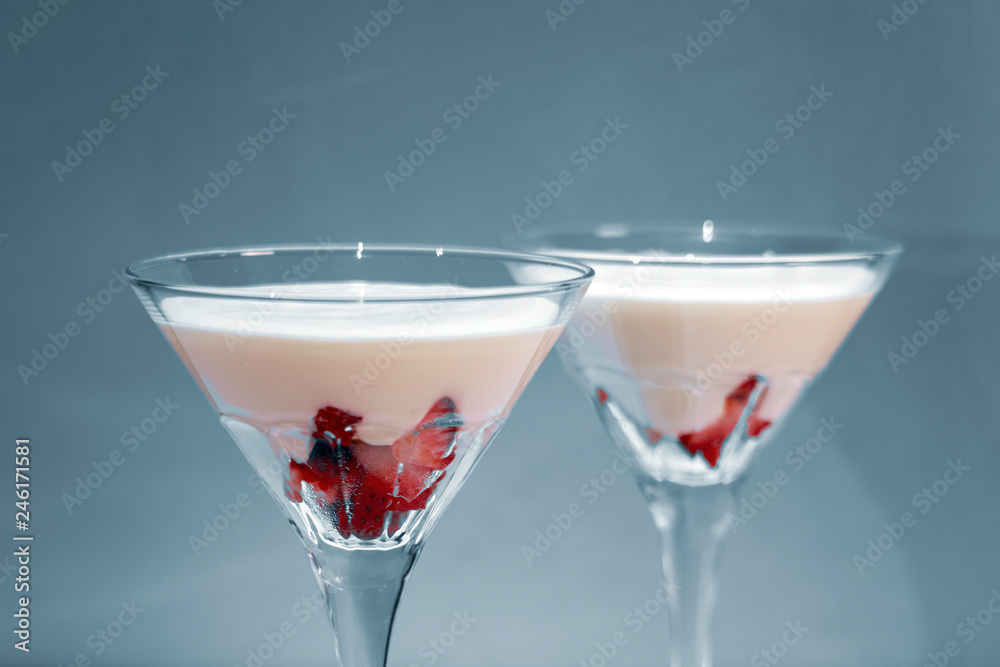 Strawberry fromage dessert in coctail glasses and lighted with artificial light. Dessert and coctail concept. Strawberry fromage dessert in coctail glasses and lighted with artificial light. Dessert and coctail concept.