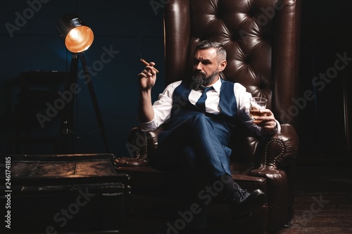 Attractive man with cigar and a glass whiskey photo