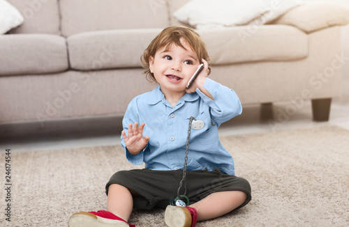 Cute baby boy talking on mobile phone photo