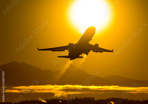 Takeoff of a passenger plane on the background of a sunset.