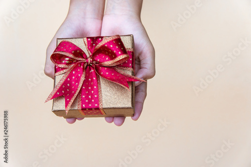 gollden gift box with red ribbow , giving gift box for special person on special day photo