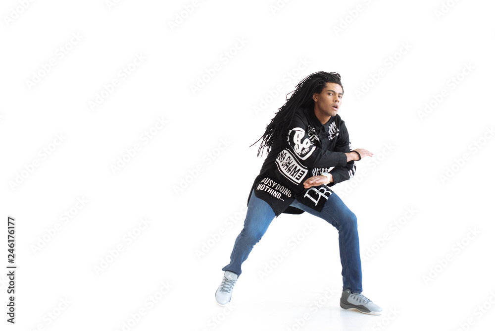 Young and stylish modern dancer. dancer with dreadlocks in a black shirt in a dance studio. Studio. White background. Young and stylish modern dancer. dancer with dreadlocks in a black shirt in a dance studio. Studio. White background.